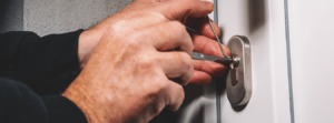 a locksmith using tools to pick a lock on a upvc door.