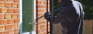 image of somebody breaking into a house for a locksmith website.